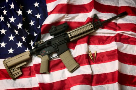 Un fusil AR-15 avec des balles sur un drapeau américain