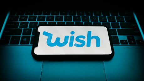 Un téléphone avec le logo de WISH placé sur un clavier de PC